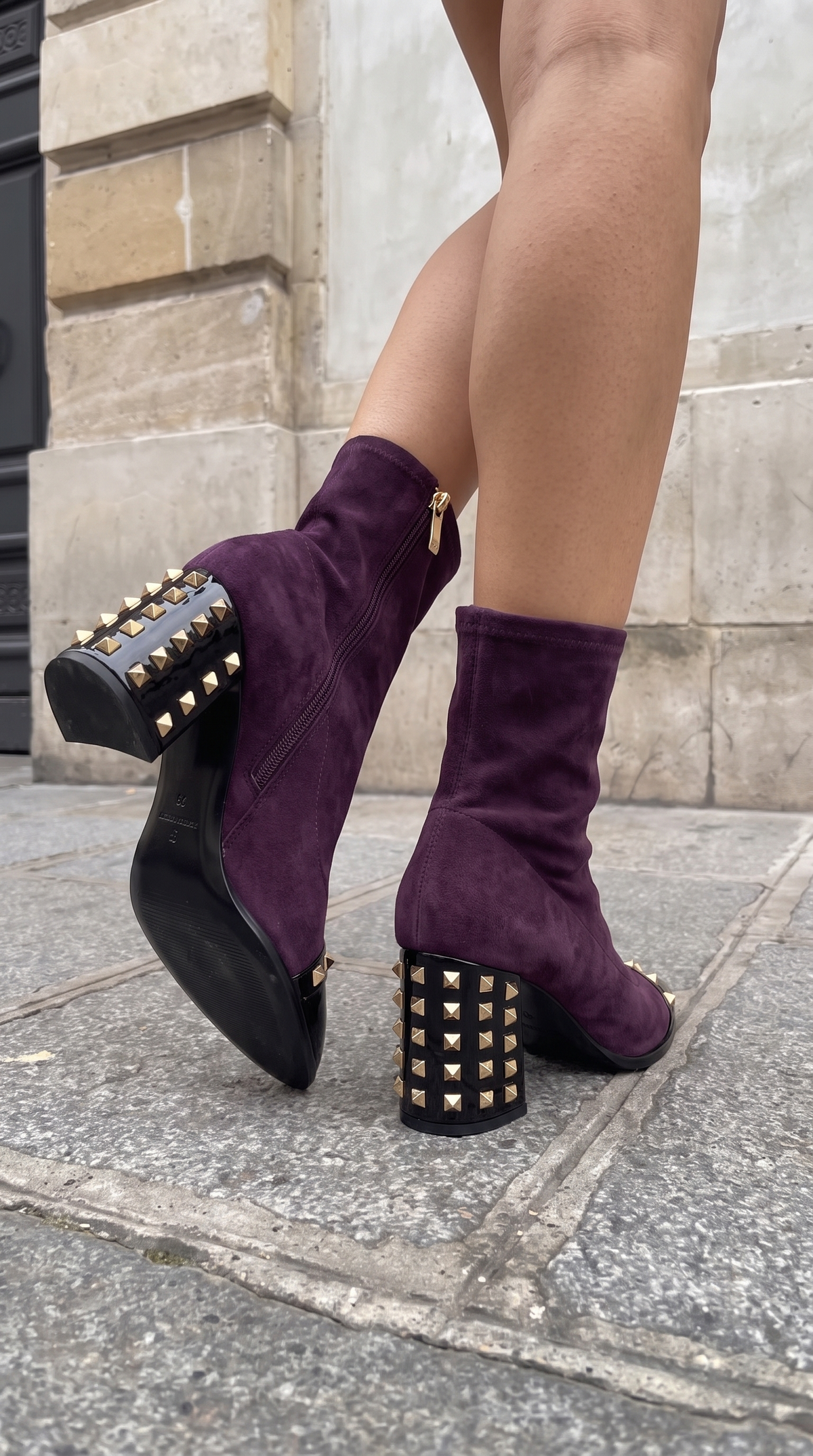 La bota de mujer de ante sintético púrpura intenso con tachuelas y amatista